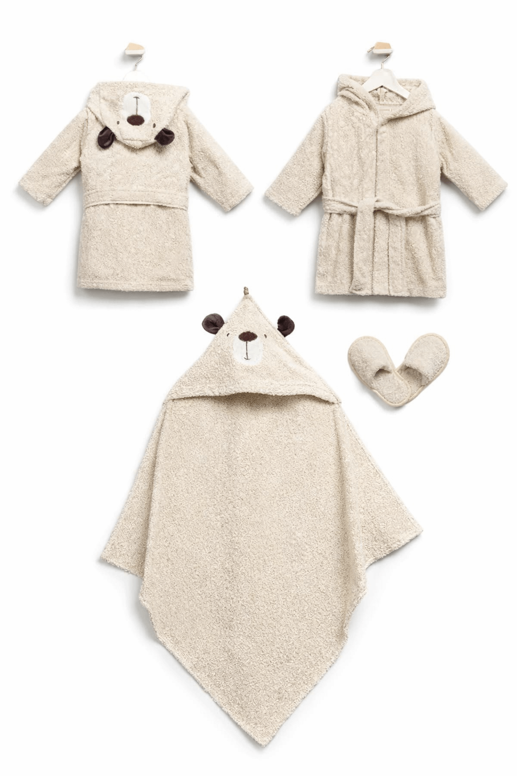 Ayıcık kapüşonlu, krem renkli bebek bornoz takımı; bornoz, panço havlu ve terlikten oluşan 3’lü set, beyaz fonda düz zemin üzerinde.