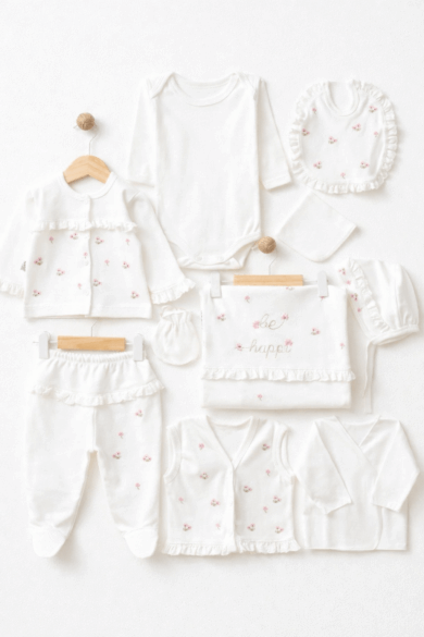 Beyaz zemin üzerinde çiçek işlemeli kız bebek 10’lu hastane çıkışı seti; body, üst, pantolon, yelek, önlük, battaniye, eldiven ve şapkadan oluşan pamuk bebek takımı